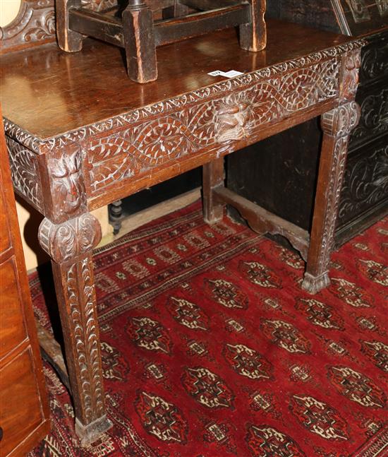 A Victorian carved oak side table, fitted one long drawer